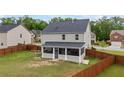 Fenced backyard with a screened-in porch, offering a private outdoor living space and green lawn at 548 Azalea Bloom Drive E, Loganville, GA 30052