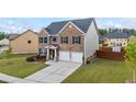 Charming two-story residence with a two-car garage, well-kept lawn, and attractive brick facade at 548 Azalea Bloom Drive E, Loganville, GA 30052