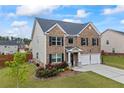 Well-maintained home with a two-car garage, neat landscaping, and classic brick and siding exterior at 548 Azalea Bloom Drive E, Loganville, GA 30052