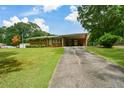 Brick home featuring a covered carport and long driveway, set on a spacious lawn at 232 Hembredge Dr, Canton, GA 30115