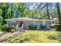 Charming single-story home features a gray brick exterior, green lawn and a red front door at 2755 Rockcliff Se Rd, Atlanta, GA 30316