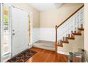 Beautiful entryway with wood floors, carpeted stairs, and adjacent paneled wainscoting at 531 Chadborn Ct, Lawrenceville, GA 30045