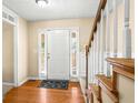 Welcoming foyer with wood floors, adjacent carpeted stairs, and white paneled wainscoting at 531 Chadborn Ct, Lawrenceville, GA 30045
