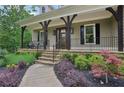 Inviting front porch with dark wood accents and manicured landscaping at 7540 Shadburn Ferry Rd, Cumming, GA 30041