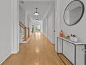 Bright hallway featuring pristine wood floors, crisp white walls, and stairway to the upper level at 4015 Wieuca Ne Rd, Atlanta, GA 30342