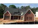 New brick home with black framed windows, dark grey roof, and a covered back patio at 101 Deer Canyon Dr, Auburn, GA 30011