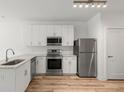 Kitchen features stainless steel appliances, including a dishwasher and range, paired with sleek white cabinetry and stone countertops at 525 Parkway Ne Dr # 110, Atlanta, GA 30354