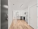 Bright living space flows into a modern kitchen with stainless steel appliances and sleek white cabinetry, enhanced by wood-look floors at 525 Parkway Ne Dr # 110, Atlanta, GA 30354