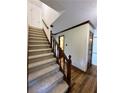 View of the carpeted staircase featuring wooden railing and trim at 5307 Red Rock Trce, Powder Springs, GA 30127