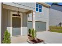 Close-up of the front porch with a gray front door, a garage, and lush greenery at 3352 Landings South Dr, Atlanta, GA 30331