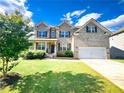 Charming two-story brick home with a well-manicured lawn and attached two car garage at 7860 Bristol Valley Dr, Cumming, GA 30028