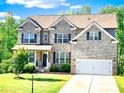 Charming two-story brick home with a well-manicured lawn and attached two car garage at 7860 Bristol Valley Dr, Cumming, GA 30028