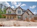 Beautiful brick home exterior featuring a covered porch and modern architectural details in a construction site at 4222 Matisse Ln, Fairburn, GA 30213
