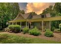 Charming single-Gathering home featuring a cozy front porch, green lawn, and lush landscaping at 116 Woolsey Creek Trl, Fayetteville, GA 30215