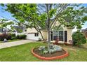 This charming home features a well-manicured lawn and a young ornamental tree at 121 St Albans Way, Peachtree City, GA 30269