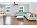 Bright living room with hardwood floors, modern ceiling fan, and a comfortable light blue sectional couch at 2247 Green Forrest Dr, Decatur, GA 30032