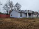 Side view of the house showcasing the lawn and red fence at 563 Fieldgreen Dr, Jonesboro, GA 30238