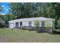 Quaint single-story house with well-maintained lawn, attached garage, and stone facade at 3000 Kennesaw Nw Dr, Kennesaw, GA 30152