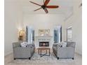 Bright living room with high ceilings, modern ceiling fan, fireplace and elegant furnishings at 1020 Regency Dr, Acworth, GA 30102