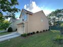 Side view of home with an attached two car garage and landscaping at 1430 Lily Valley Dr, Lawrenceville, GA 30045