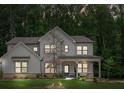 Charming two-story home featuring a covered front porch and a neatly maintained front yard with greenery at 172 Aspen Hall Dr, Canton, GA 30115