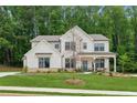 Beautiful two-story home with covered front porch, green lawn, and elegant landscaping at 172 Aspen Hall Dr, Canton, GA 30115