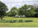 Quaint single-story home with a large front yard and mature trees, offering a serene setting at 235 Creekside Way, Mcdonough, GA 30252
