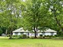 Traditional single-story house with a symmetrical facade, lush green lawn, and large trees at 235 Creekside Way, Mcdonough, GA 30252