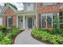 Inviting front entrance with a curved walkway, colorful landscaping, and classic columns at 4170 Haynes Mill Nw Ct, Kennesaw, GA 30144