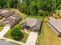 Stunning aerial view of a home with a well-maintained lawn, mature trees, and nice neighborhood at 6995 Tybridge St, Cumming, GA 30040