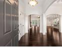 Bright foyer with hardwood floors, archways, and natural light streaming in from the living area and kitchen at 6995 Tybridge St, Cumming, GA 30040