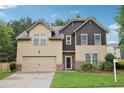 Two-story home with a two-car garage, manicured lawn, and mature landscaping at 2760 Lions Gate Dr, Cumming, GA 30041