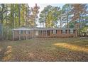 Traditional brick home with a well-manicured lawn and mature trees providing ample shade at 3497 Highway 5, Douglasville, GA 30135