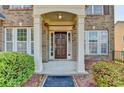 A warm and inviting front entrance with a covered porch and manicured shrubbery at 645 Earlham Dr, Suwanee, GA 30024