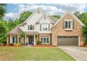 Charming two-story brick and siding home with well-maintained landscaping, lawn and a two-car garage at 3874 Lost Oak Dr, Buford, GA 30519