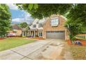 Attractive two-story home featuring a brick facade, a two-car garage, mature landscaping, and a well-kept lawn at 3874 Lost Oak Dr, Buford, GA 30519