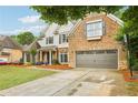 Traditional brick home with a two car garage, well-manicured lawn, and mature trees at 3874 Lost Oak Dr, Buford, GA 30519