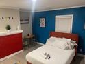 Comfortable bedroom with red accent wall, colorful decor, and queen bed with soft white linens at 10 Rockmart Nw Dr, Atlanta, GA 30314