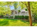 A well-manicured lawn leads to a cozy porch with decorative accents, enhancing the home's inviting facade at 1150 Kennesaw Due West Nw Rd, Kennesaw, GA 30152