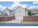 Rear of home featuring a 2-car garage and well-maintained fenced backyard at 4448 Tacoma Trce, Suwanee, GA 30024