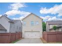 Rear of home featuring a 2-car garage and well-maintained fenced backyard at 4448 Tacoma Trce, Suwanee, GA 30024