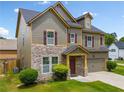 Charming home features stone accents, neutral siding, and a two-car garage at 4920 Fourth Rail Ln, Cumming, GA 30040