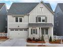 Charming two-story home with board and batten siding, shutters, a two-car garage, and a well-manicured front yard at 1006 Fendley St, Woodstock, GA 30188