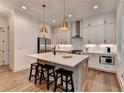 Modern kitchen features stainless steel appliances, an island with bar seating, and elegant pendant lighting at 1006 Fendley St, Woodstock, GA 30188