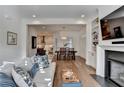 Open-concept living room boasts hardwood floors, a fireplace, comfortable seating, and an open view to the kitchen at 1006 Fendley St, Woodstock, GA 30188