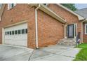 Close-up of a brick home with an attached garage and a decorative glass front door with steps at 1523 Pangborn Station Dr, Decatur, GA 30033