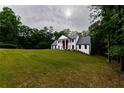 Elegant, two-story home with a manicured lawn and column-lined entryway, nestled among lush trees at 4 Bentley Trace Mnr, Atlanta, GA 30327