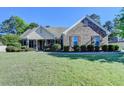 Charming single-story brick home with manicured lawn and mature trees at 1550 Misty Valley Dr, Lawrenceville, GA 30045