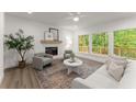 Inviting living room featuring large windows, a cozy fireplace, and neutral décor at 216 Creek View Pl, Canton, GA 30114