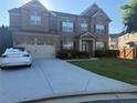 Well-manicured lawn fronts this beautiful two-story brick home with attached garage at 3670 Kissell Dr, Cumming, GA 30041